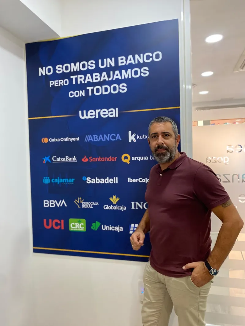Andrés Broullón, especialista en intermediación financiera, junto al panel de bancos con los que trabaja Wereal en Alicante
